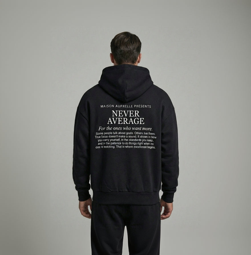 Person wearing a black hoodie with text on the back against a gray background