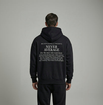 Person wearing a black hoodie with text on the back against a gray background