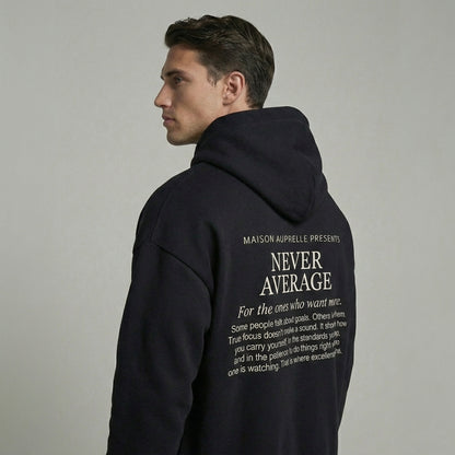 Man wearing a black hoodie with text on the back against a gray background