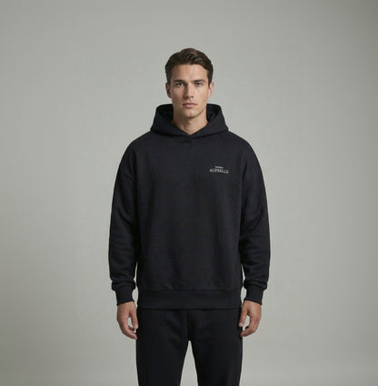 Man wearing a black hoodie with brand logo on a gray background